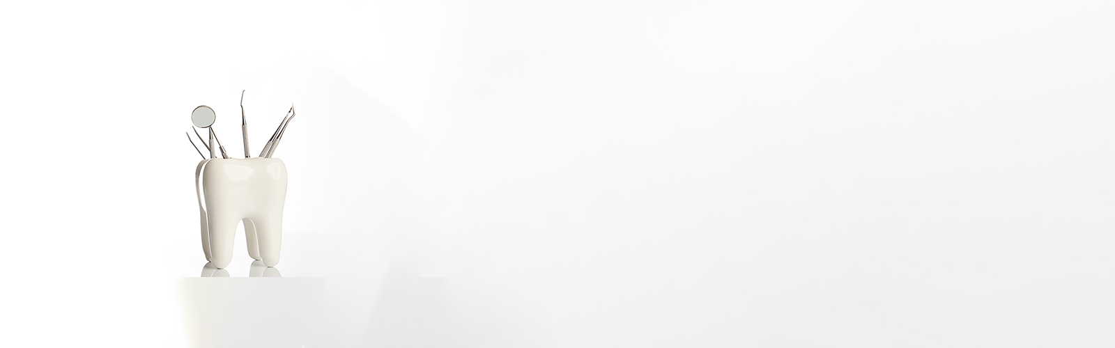 The image shows a small figurine of a person standing on a white surface, positioned in the foreground with a blurred background that appears to be a plain wall.