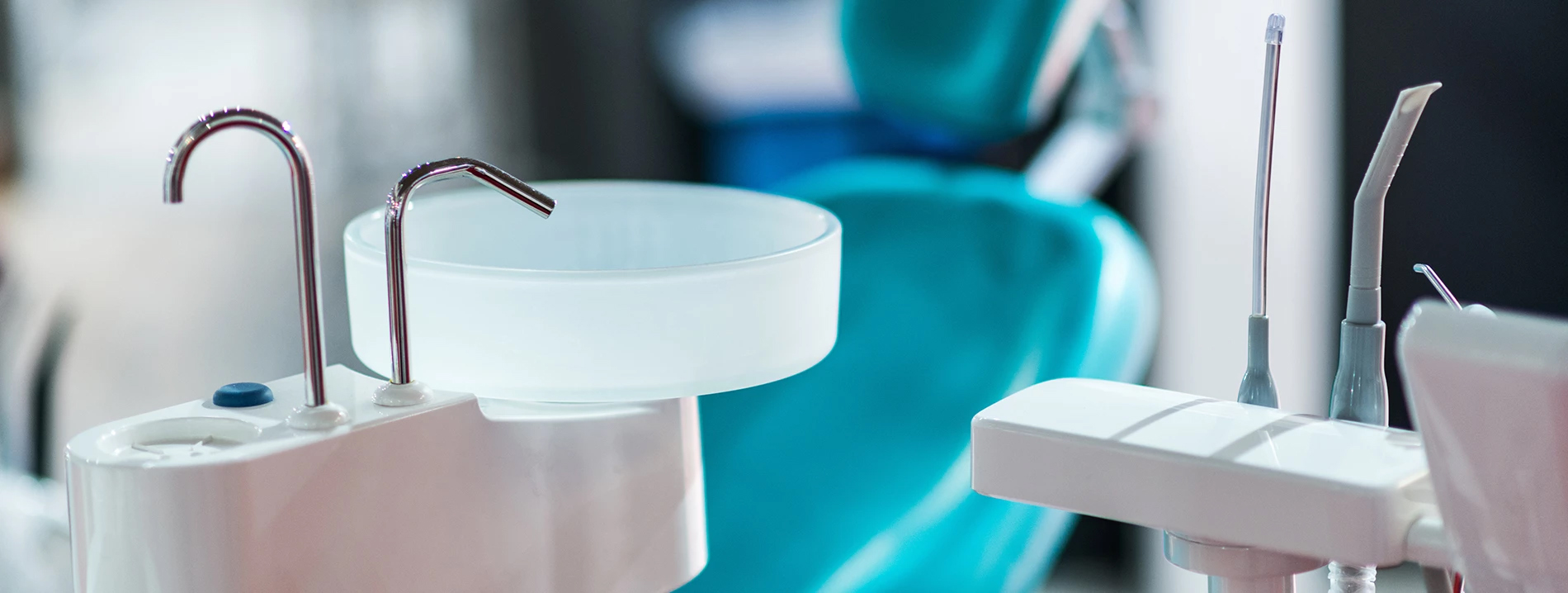 The image shows a collection of dental instruments, including tweezers and other tools, displayed on a stand with a blue background.