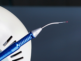 An electric toothbrush with a blue handle and a red bristle head.