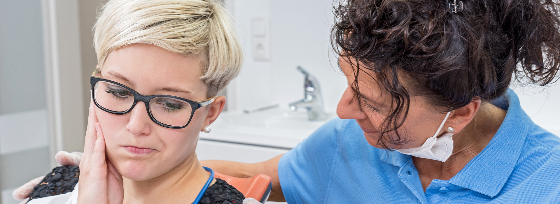 Woman receiving dental care from a professional in a dental office setting.