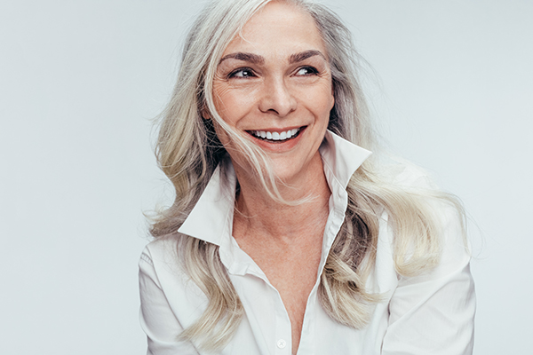 A woman with short hair is smiling and looking directly at the camera.